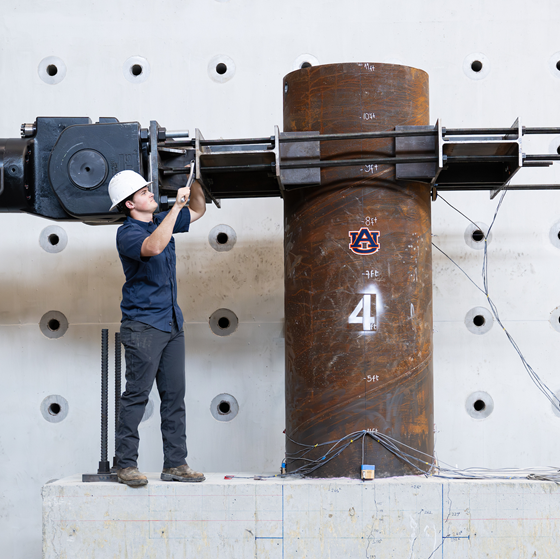 student in hardhat working in Advanced Structural Engineering Laboratory