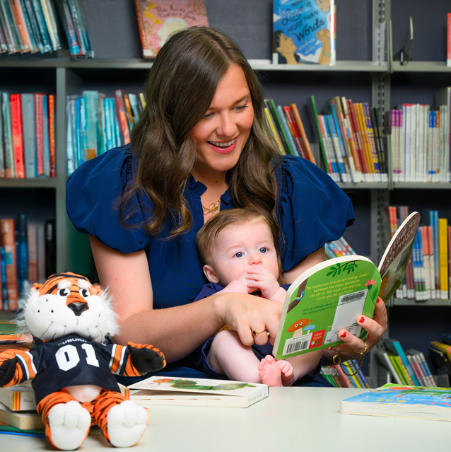 mother and baby looking at book in library