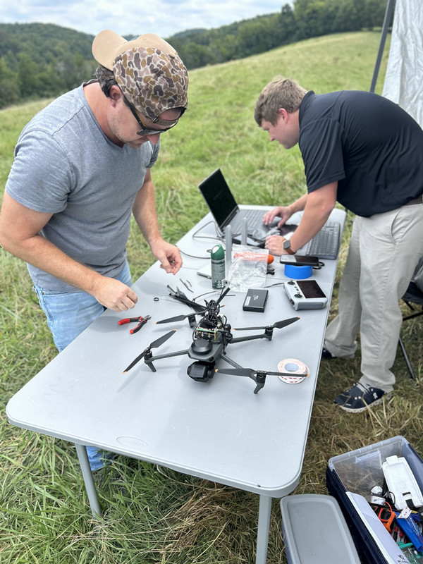 men working on drones in the field