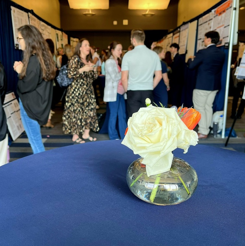 floral display at symposium with participants in the background